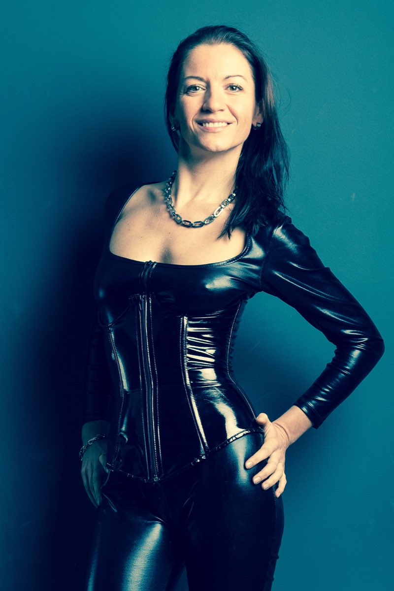 Illustrative stock portrait of a smiling adult in a dark outfit against a blue background