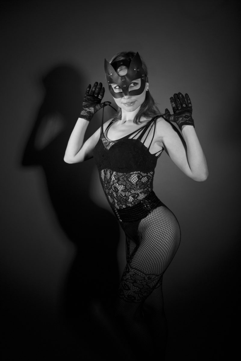 Illustrative black and white stock photograph of an adult wearing a masquerade mask, not a real member from Ireland