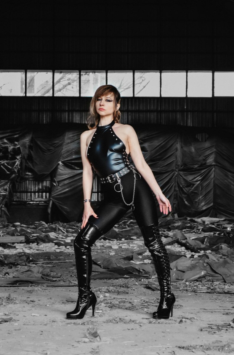 Illustrative stock photograph of an adult in a black outfit in an industrial setting, not a member of Pegging Live
